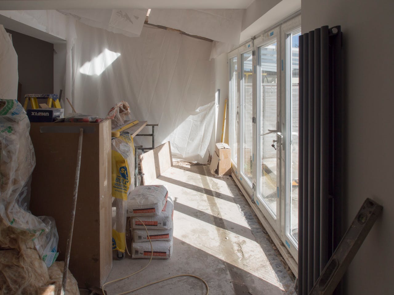 our-experience A construction area featuring renovation work in progress with large windows bringing in natural light.